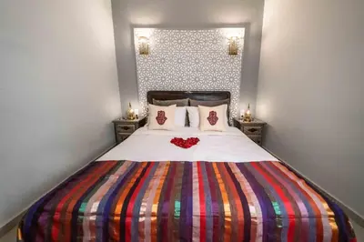 a bedroom with a large bed with a colorful blanket at Riad Kiyanjana in Marrakech