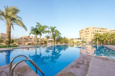 a large swimming pool with palm trees and a building at Luxury Place M Avenue in Marrakech