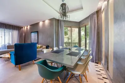 a dining room with a table and blue chairs at Relax Front Of Pool-Golf-Atlas in Marrakech