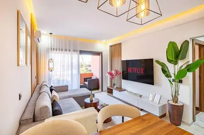 a living room with a couch and a tv at Luxury Apartment Gueliz, Cinema Bedroom Experience in Marrakech