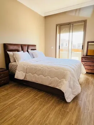 a large bed in a bedroom with a wooden floor at Les palmiers de marrakesh in Donar Zratna