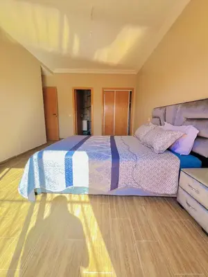 a bedroom with a large bed and a wooden floor at Les palmiers de marrakesh in Donar Zratna