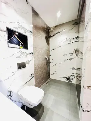 a white bathroom with a toilet and a shower at Les palmiers de marrakesh in Donar Zratna