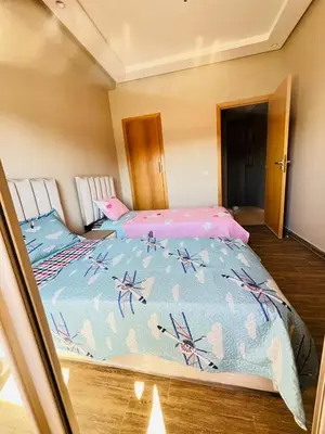 a bedroom with a large bed with a blue comforter at Les palmiers de marrakesh in Donar Zratna