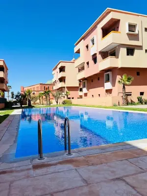 a swimming pool in front of a building at Les palmiers de marrakesh in Donar Zratna