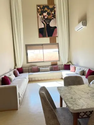 a living room with a couch and a table at Les palmiers de marrakesh in Donar Zratna