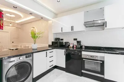 a kitchen with white cabinets and a washer and dryer at Luxury Odyssey - Marrakech Centre in Marrakech