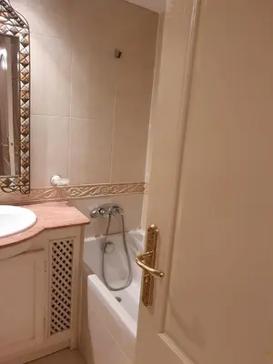 a bathroom with a tub and a sink and a door at Appartement Guéliz Centre Marrakech in Marrakech