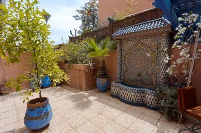 a patio with potted plants and a bench at Appartement Guéliz Centre Marrakech in Marrakech