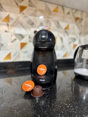 a black coffee pot on a counter with two orange buttons at The Cosy Duplex With Gym Access & Near Mall, Palooza in Marrakech