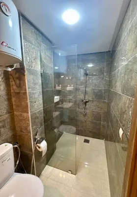 a bathroom with a glass shower with a toilet at The Cosy Duplex With Gym Access & Near Mall, Palooza in Marrakech