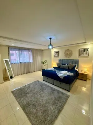 a bedroom with a blue bed and a rug at The Cosy Duplex With Gym Access & Near Mall, Palooza in Marrakech