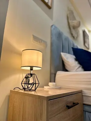 a lamp on a table next to a bed at The Cosy Duplex With Gym Access & Near Mall, Palooza in Marrakech
