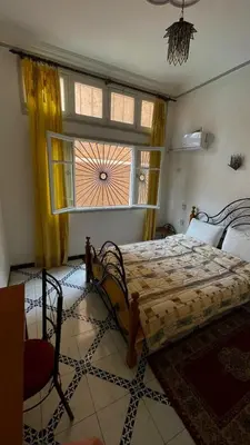 a bedroom with a bed and a large window at Residence Koutoubienne in Marrakech