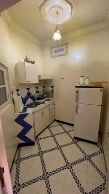 a kitchen with a refrigerator and a tiled floor at Residence Koutoubienne in Marrakech