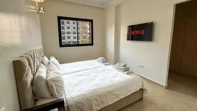 a bedroom with a bed and a clock on the wall at Spacious Apartment 102m2 3 Bedrooms 2 Bathrooms 8 Guests Elevator Self Check in in Marrakech