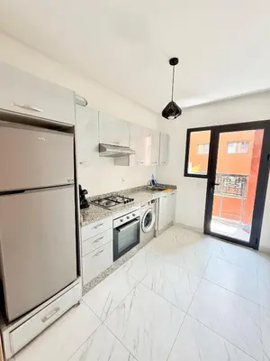 a white kitchen with a stove and a refrigerator at Confortable & Spacieux & Au Centre-ville in Marrakech