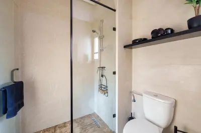 a bathroom with a toilet and a glass shower at Appart View Pool - 3 Rooms - Optical Fiber in Marrakech