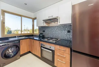 a kitchen with a stove and a dishwasher at Luxueux appartement prestigia golf/vue piscine in Marrakech