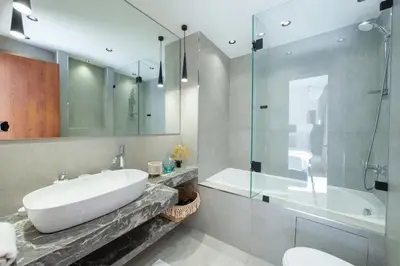 a bathroom with a sink and a shower and a tub at Luxueux appartement prestigia golf/vue piscine in Marrakech