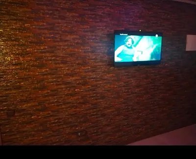 a television on a brick wall in a room at Appartement de luxe à louer in Marrakech