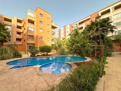 a swimming pool in front of a building at Cozy apartment pool marrakech morocco in Marrakech