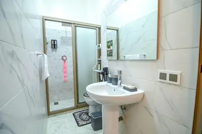 a white bathroom with a sink and a shower at The Skyline Stay in Marrakech