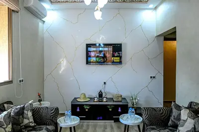 a living room with two couches and a tv on a wall at The Skyline Stay in Marrakech