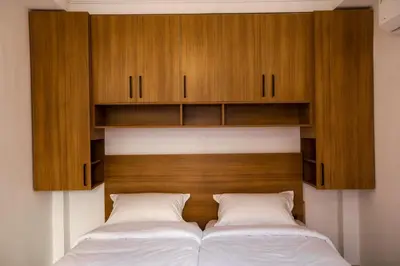 two beds with wooden cabinets above them in a bedroom at Marrakech Apartments in Marrakech