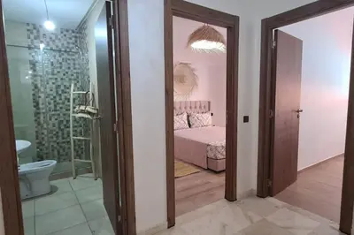 a room with a bedroom with a bed and a bathroom at Appartement 2 chambres vue Piscine à Guèliz en face la gare de train marrakech in Marrakech