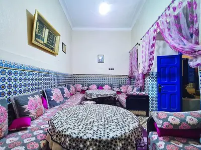 a room with pink and purple furniture and a table at Riad Sultana - 10 min à pied de Jemaa El Fna in Marrakech