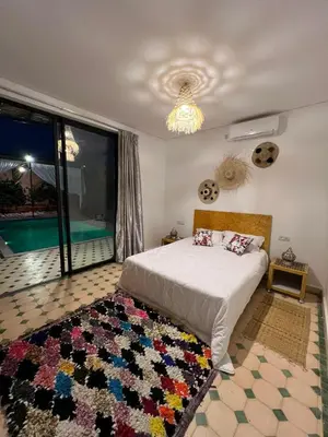 a bedroom with a bed and a rug on the floor at La villa Berbère - Famille uniquement in Marrakech