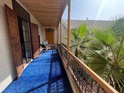 a balcony of a house with a palm tree at Riyad Lion Rouge in Marrakech