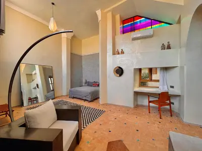 a living room with a couch and a stained glass window at Riyad Lion Rouge in Marrakech