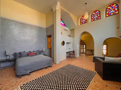 a bedroom with a bed and stained glass windows at Riyad Lion Rouge in Marrakech