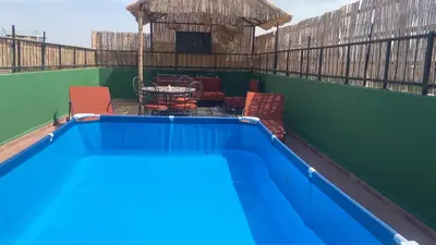 a blue swimming pool with chairs and a table at Appartement MSholidays Gazelle Marrakech in Marrakech