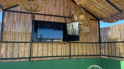 a room with a television in a straw wall at Appartement MSholidays Gazelle Marrakech in Marrakech