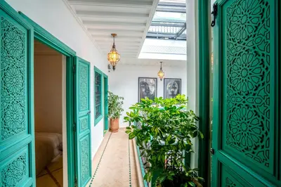 a hallway with green doors and potted plants at Riad Bella Kasbah in Marrakech