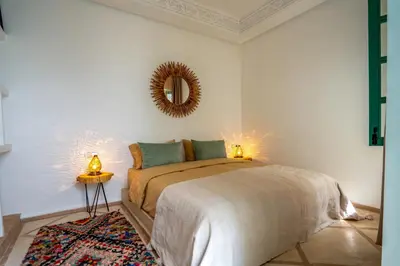 a bedroom with a bed and a mirror on the wall at Riad Bella Kasbah in Marrakech