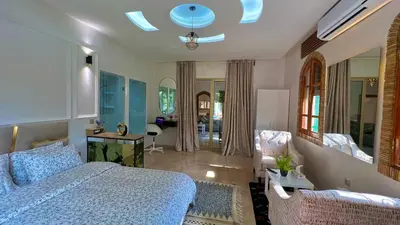 a bedroom with a bed and a living room at Luxurious Villa with private pool, Jacuzzi & Cuisinière in Marrakech