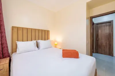 a bedroom with a large white bed and a window at Appartement 2 chambres Aéroport in Marrakech