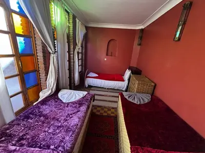 a small room with two beds and a window at Riad Lwalidin in Marrakech