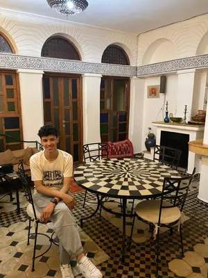 a man sitting in front of a table in a room at Riad Lwalidin in Marrakech