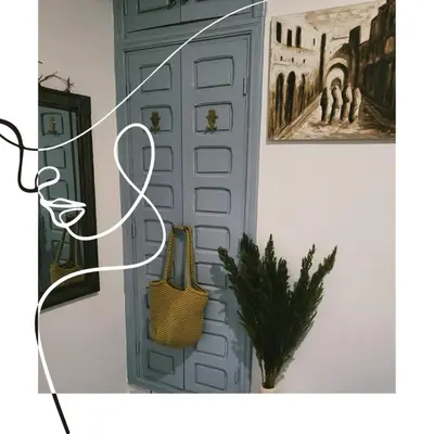 a door in a room with a painting and a plant at Riad traditionnel de charme 3 chambres in Marrakech
