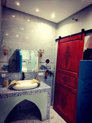 a bathroom with a red door and a sink at RIAD & SPA SOUS LE SOLEIL CHEZ Jérôme & Paméla in Marrakech