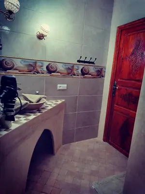 a bathroom with a sink and a red door at RIAD & SPA SOUS LE SOLEIL CHEZ Jérôme & Paméla in Marrakech
