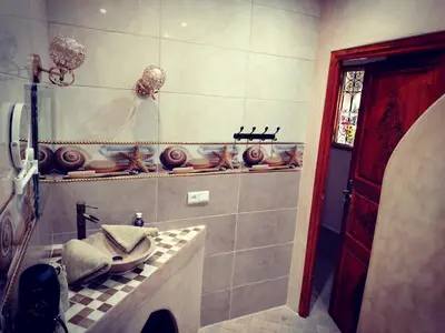 a bathroom with a sink and a tiled floor at RIAD & SPA SOUS LE SOLEIL CHEZ Jérôme & Paméla in Marrakech