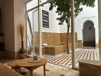 a room with a bath tub and a table and a table sidx sidx at Neroli le Riad, idéalement situé in Marrakech