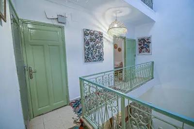 a hallway with a staircase with a green door at Oasis Medina Hostel in Marrakech