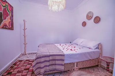 a bedroom with a bed and a chandelier at Oasis Medina Hostel in Marrakech